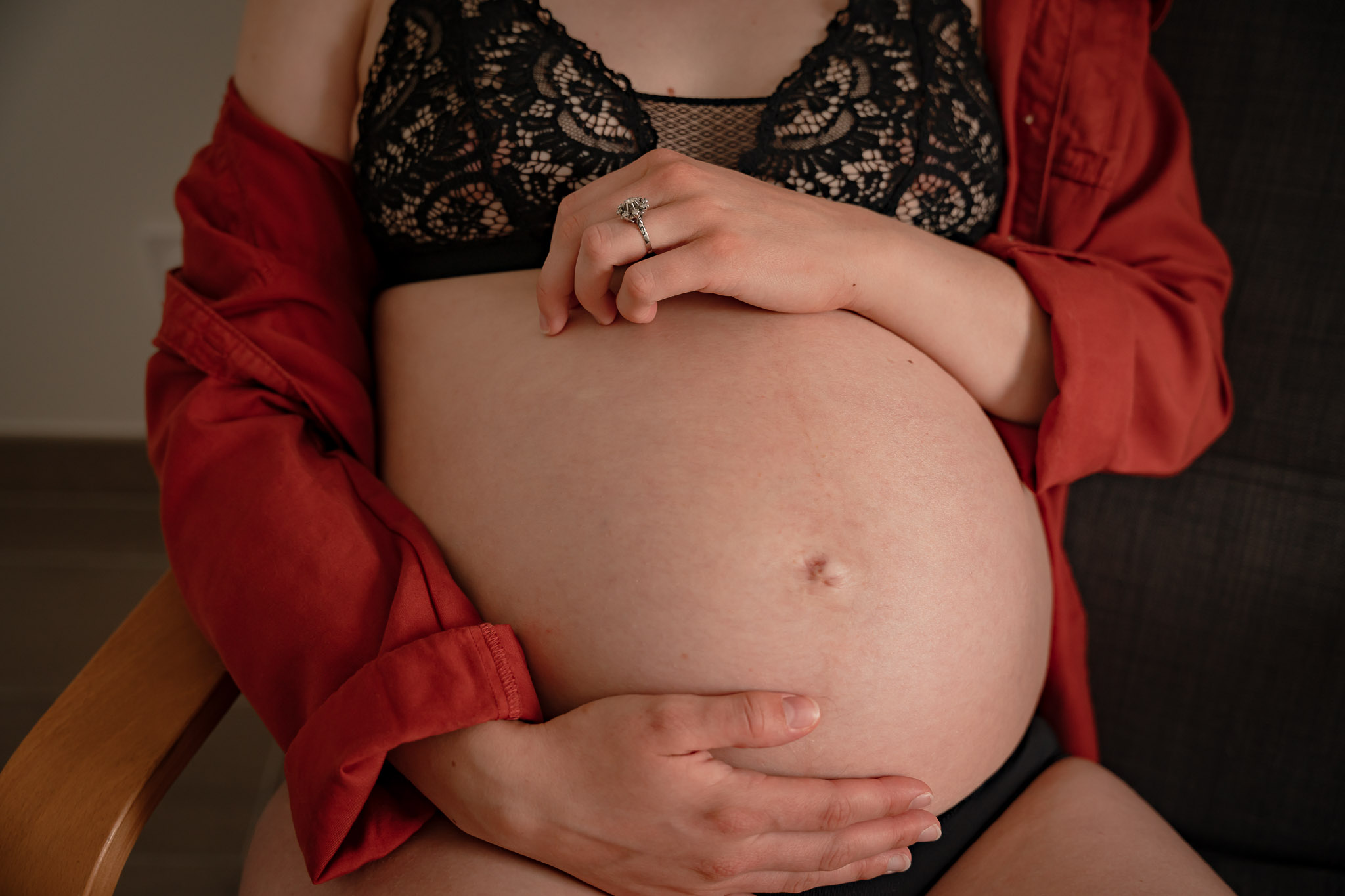 Focus sur le ventre d'une femme enceinte lors d'un shooting photo maternité