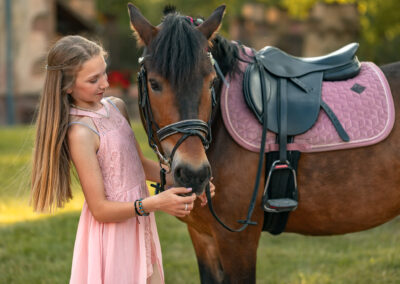 Photo artistique d'une fille qui caresse son cheval dans la cour du chateau