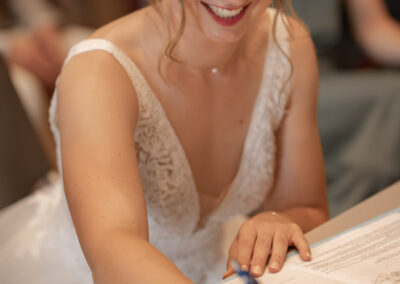 La mariée qui signe les registres lors de la cérémonie de mariage à la mairie de Paris