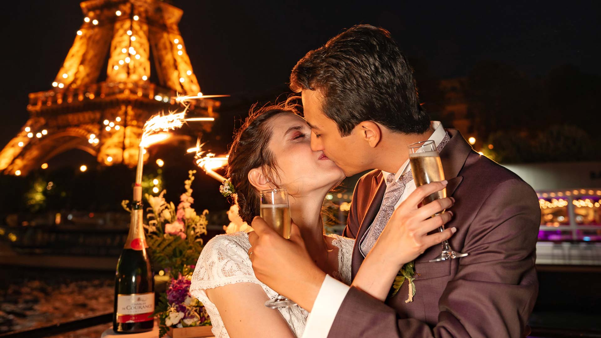 Mariage sur une péniche à Paris avec les mariés qui s'embrassent devant la Tour Eiffel