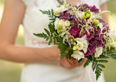 Photo artistique du bouquet de fleur du mariage à Paris avec la robe de mariée