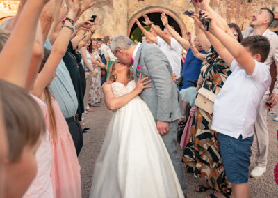Mariage au chateau de Thanvillé - Les mariés s'embrassent entourés de leur invités au chateau de Thanvillé en Alsace
